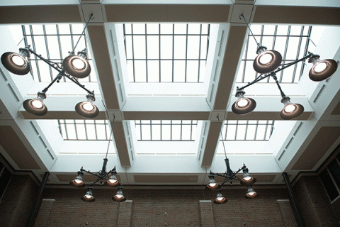 Large circular lamps and large windows that make up the ceiling in the atrium of the Bayh College of Education.